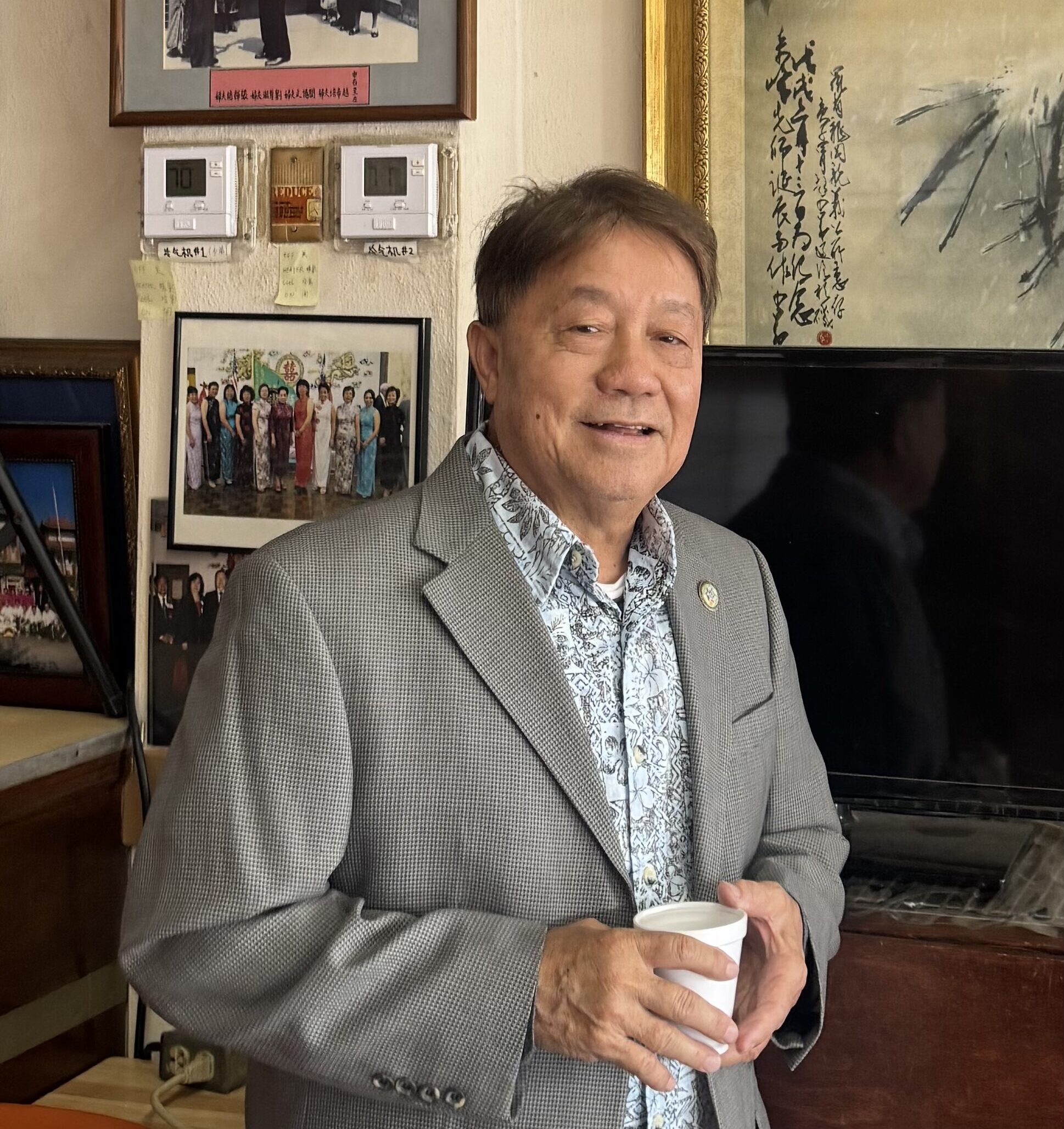 Headshot of Gary "Kwan" Jue smiling and holding a cup