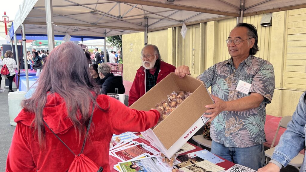 Vice President Gordon Hom handing out fortune cookies at the Firecracker Run