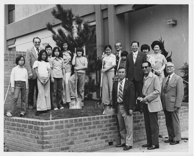 Black and white photos of a group of school administrators, members of the Chinese Consolidated Benevolent Association (CCBA), Castelar Elementary School students and parents standing on and around a brick raised bed at Castelar Elementary school